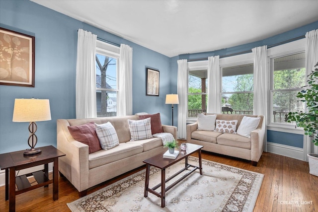 living room with plenty of natural light, baseboards, and wood finished floors