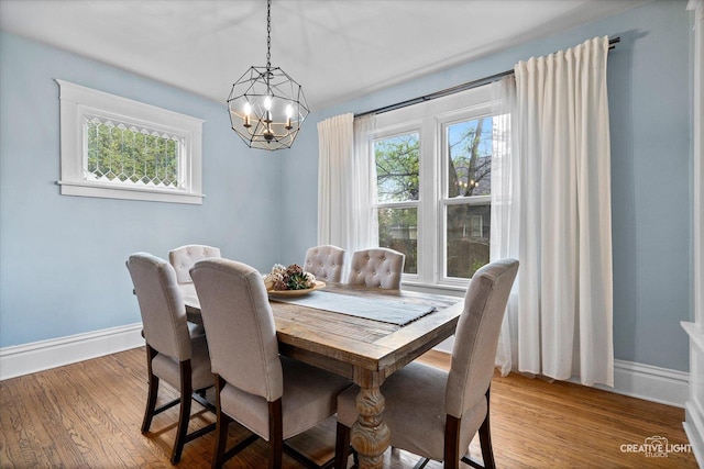 dining room with an inviting chandelier, baseboards, and wood finished floors