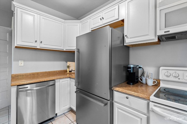 kitchen featuring appliances with stainless steel finishes, light tile patterned floors, and white cabinets