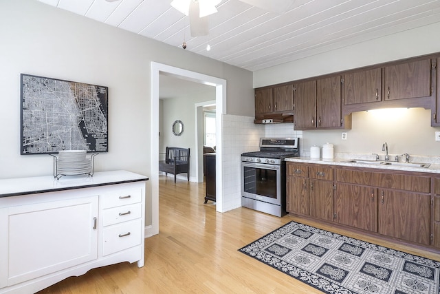 845 Smith St, Glen Ellyn, IL 60137 - kitchen featuring stainless steel gas range, under cabinet range hood, a sink, light wood finished floors, and decorative backsplash
