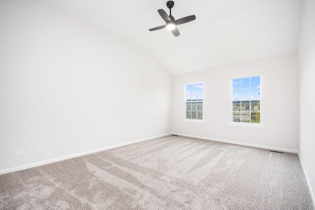 carpeted spare room with baseboards, a ceiling fan, and vaulted ceiling
