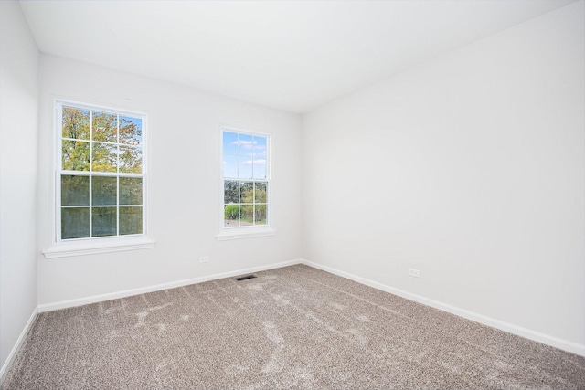carpeted empty room with baseboards