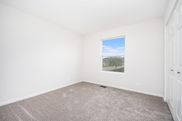 unfurnished bedroom with a closet, carpet, baseboards, and visible vents