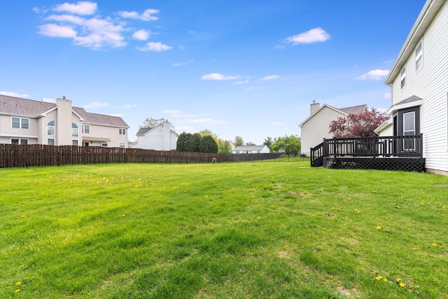 view of yard featuring a wooden deck, a residential view, and fence
