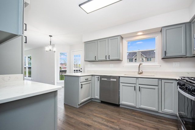 kitchen featuring dark wood-style flooring, black gas range oven, a sink, stainless steel dishwasher, and gray cabinetry