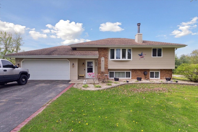 tri-level home featuring a front lawn, aphalt driveway, a chimney, brick siding, and an attached garage
