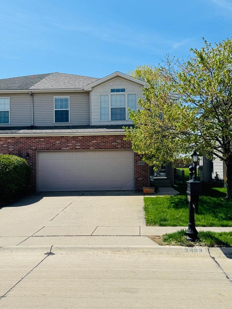 view of front of property featuring a garage, concrete driveway, and brick siding