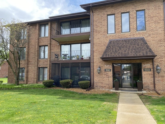 exterior space featuring a lawn and brick siding