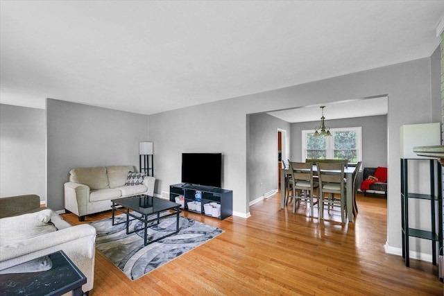 307 Dodson Dr W, Urbana, IL 61802 - living area featuring baseboards, wood finished floors, and an inviting chandelier