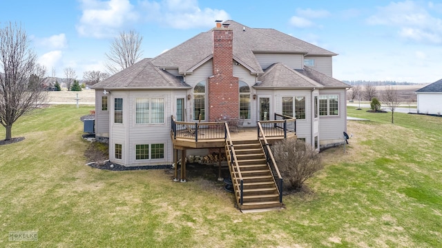 rear view of property with a chimney, roof with shingles, a deck, stairway, and a yard