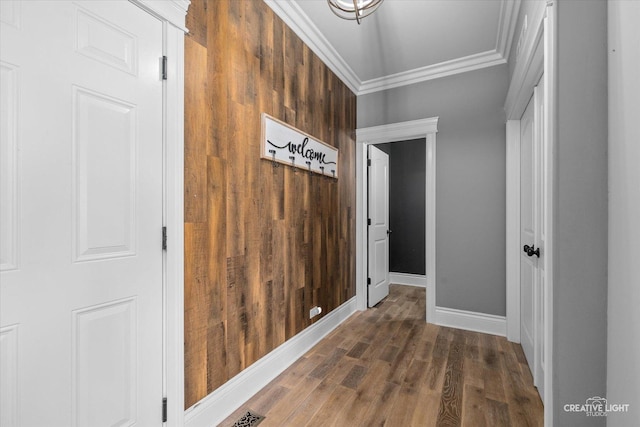 corridor featuring baseboards, ornamental molding, and dark wood-style flooring