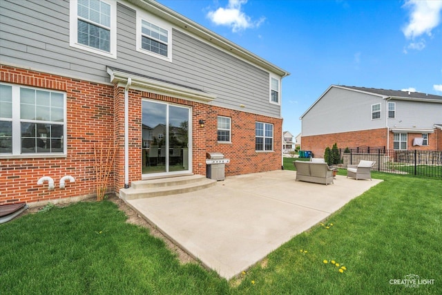 back of house with a lawn, fence, brick siding, and a patio