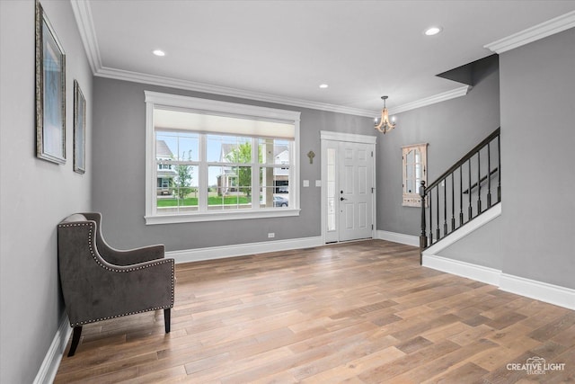 entryway featuring crown molding, stairs, a notable chandelier, and wood finished floors