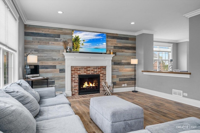 living room with wooden walls, baseboards, crown molding, and visible vents