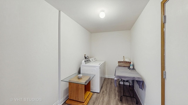laundry area featuring washing machine and dryer, light wood-type flooring, and baseboards