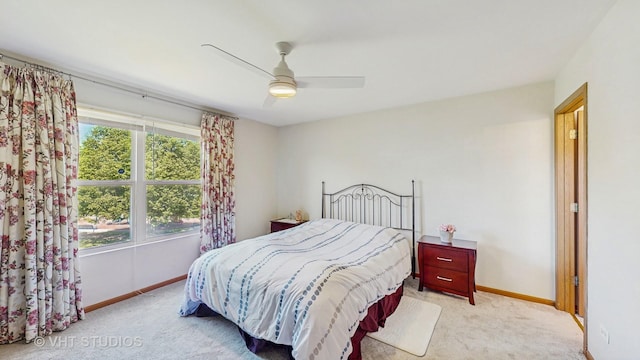 bedroom featuring light colored carpet, baseboards, and ceiling fan