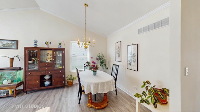 dining area with wood finished floors, a chandelier, crown molding, lofted ceiling, and baseboards