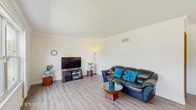 living room with wood finished floors, crown molding, and baseboards