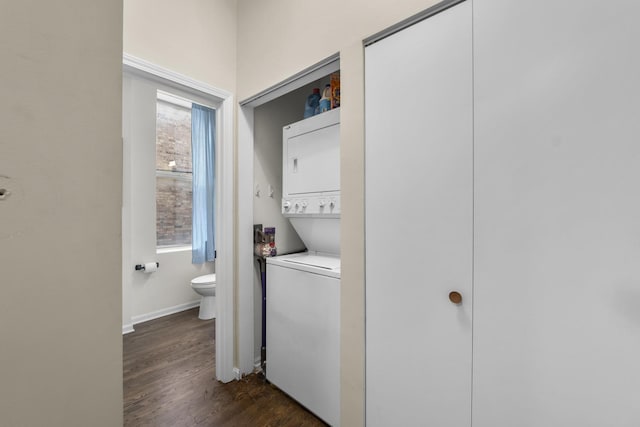 laundry room with stacked washing machine and dryer, dark wood finished floors, and baseboards