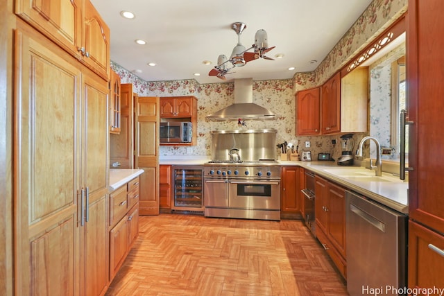 kitchen featuring wall chimney exhaust hood, stainless steel appliances, a sink, wine cooler, and light countertops