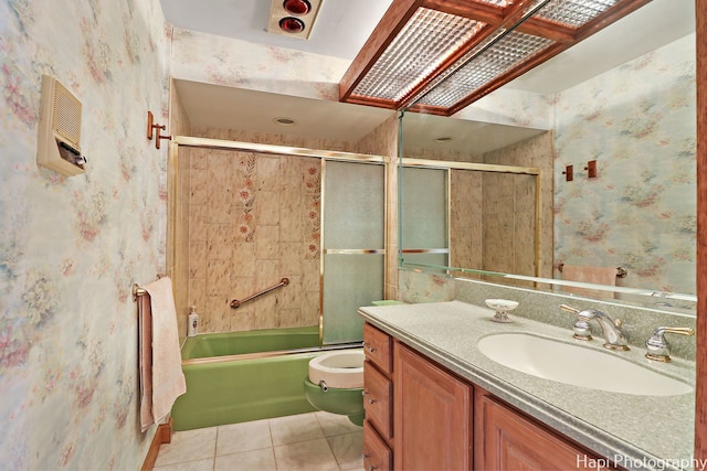 bathroom featuring wallpapered walls, tile patterned floors, combined bath / shower with glass door, vanity, and toilet