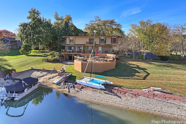 rear view of property featuring a yard and a deck with water view