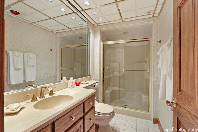 bathroom featuring wallpapered walls, a stall shower, tile patterned floors, vanity, and toilet