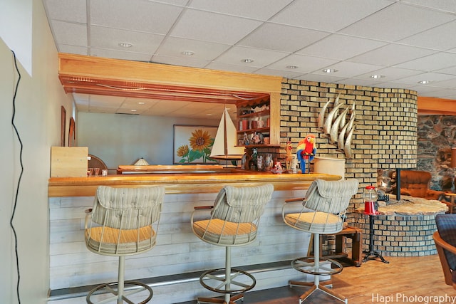 indoor dry bar with a drop ceiling, wood finished floors, and recessed lighting