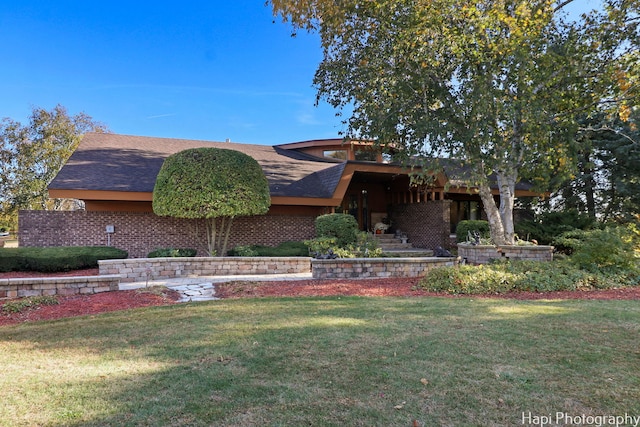 view of front of property with a front lawn and a shingled roof