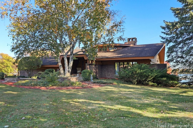 mid-century modern home with a front yard and a chimney