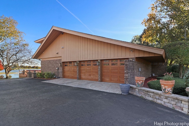 view of side of property with brick siding and a detached garage