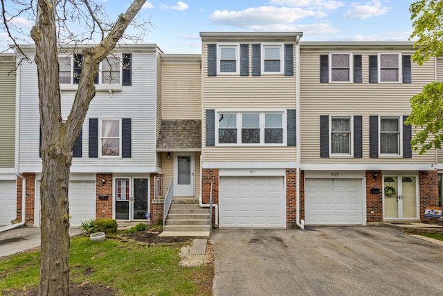 907 Banbury Ct, Schaumburg, IL 60194 - townhome / multi-family property featuring a garage, brick siding, and driveway