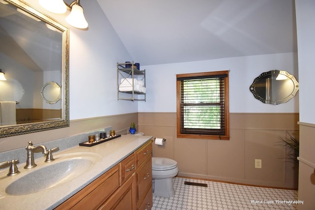 5N850 Ravine Dr, Saint Charles, IL 60175 - bathroom featuring vaulted ceiling, vanity, toilet, and a wainscoted wall