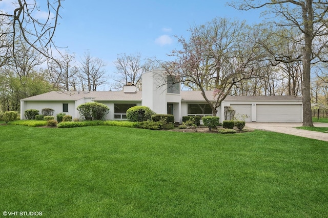 view of front of property featuring driveway, a front lawn, stucco siding, and an attached garage