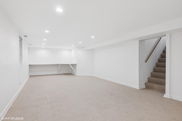 finished below grade area with recessed lighting, stairway, and baseboards