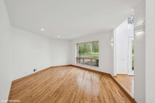 spare room with light wood-type flooring, baseboards, and recessed lighting