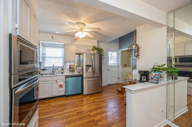 545 Morris Ave, Bellwood, IL 60104 - kitchen featuring appliances with stainless steel finishes, a sink, ceiling fan, wood finished floors, and a textured ceiling