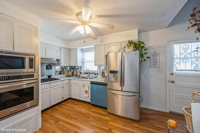 545 Morris Ave, Bellwood, IL 60104 - kitchen with stainless steel appliances, a sink, light wood finished floors, a textured ceiling, and light countertops