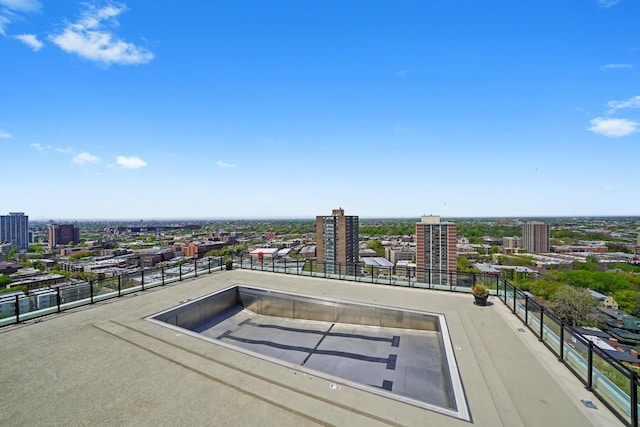 view of pool featuring a city view and fence