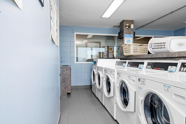 shared laundry room with washer and dryer, light tile patterned floors, and tile walls