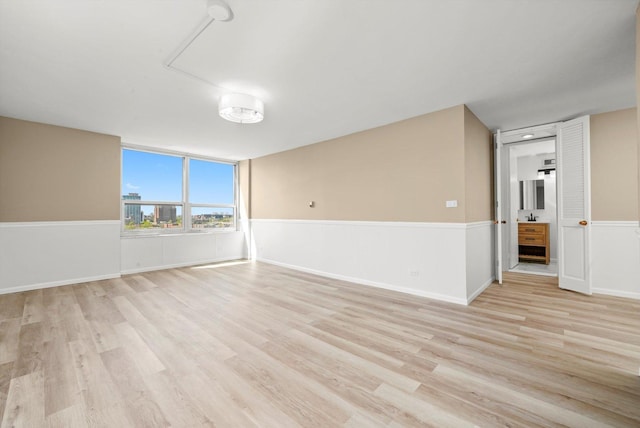 empty room featuring light wood-style floors and baseboards