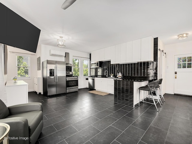 213 S Ashland Ave, La Grange, IL 60525 - kitchen with stainless steel appliances, dark countertops, wall chimney range hood, and plenty of natural light