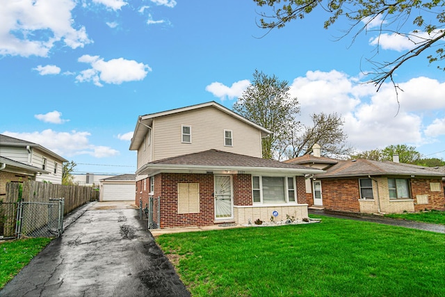 view of front facade with a front yard, an outbuilding, a garage, brick siding, and fence