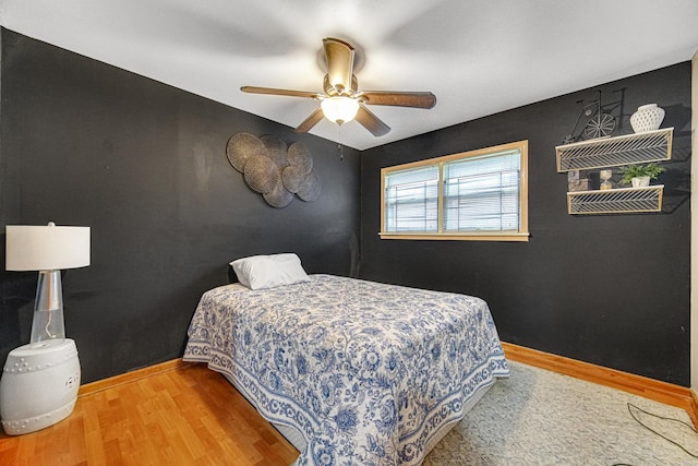 bedroom with baseboards, ceiling fan, and wood finished floors