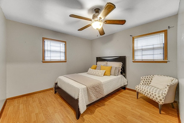 bedroom featuring baseboards, ceiling fan, and light wood-style flooring