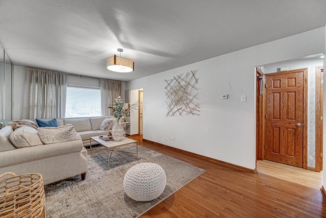 living area featuring baseboards and wood finished floors
