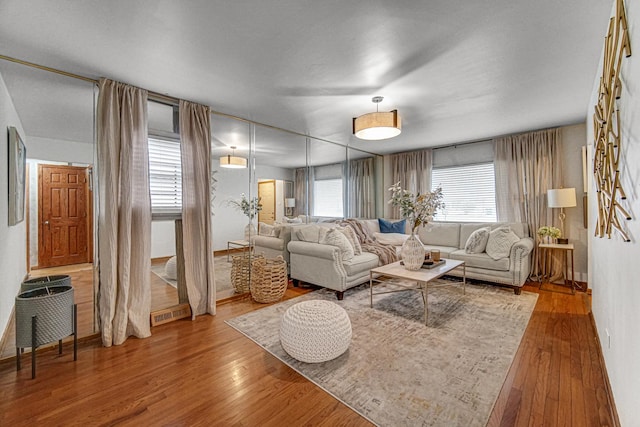 living area with baseboards and wood finished floors