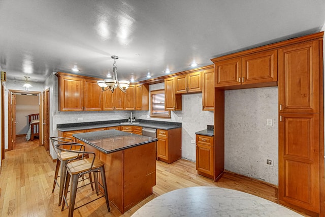 kitchen with a kitchen island, brown cabinets, and light wood-style flooring