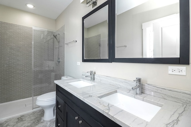 bathroom featuring tiled shower, toilet, and double vanity
