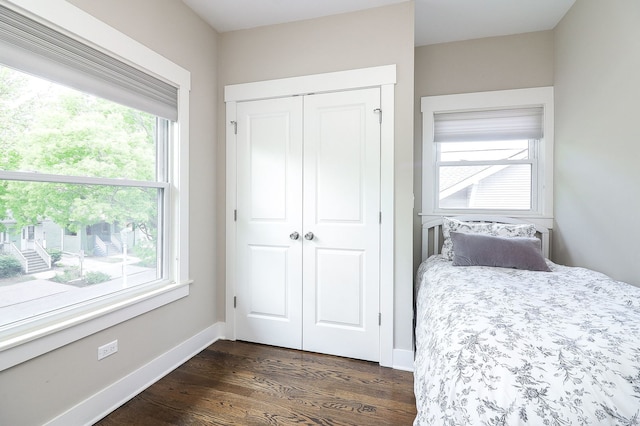 bedroom featuring dark wood-type flooring, a closet, and baseboards